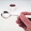 JoeFrex cupping lepel in de hand bij een kop koffie