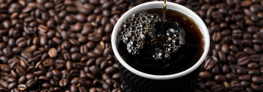 Americano with coffee beans in background